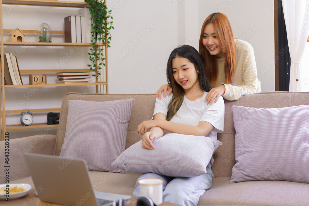 Relaxation concept, Lesbian female sits on couch with girlfriend stand behind her to watching movie