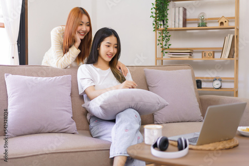 Relaxation concept, Lesbian female sits on couch with girlfriend stand behind her to watching movie