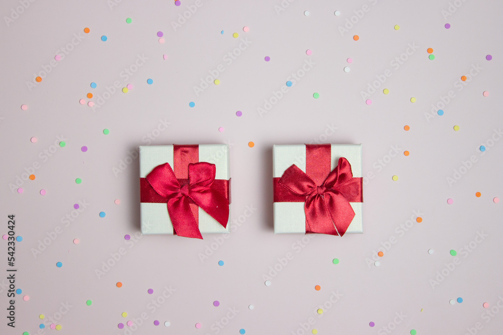Gift boxes with colorful confetti over the pink background. Gift boxes with colorful confetti over the pink background.