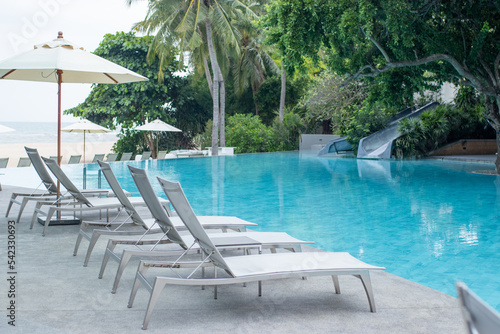Gray pool lounge chairs by swimming pool..