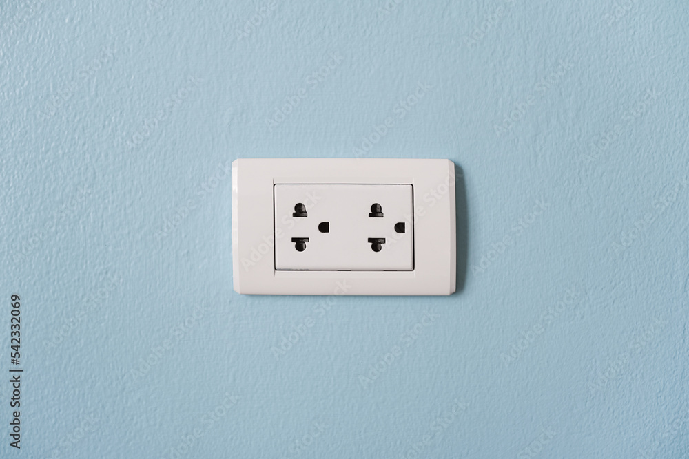 Electrical plug socket on the blue cement wall. Energy use in home. Electricity consumption. Electrical plug socket on the blue cement wall. Energy use in home. Electricity consumption.