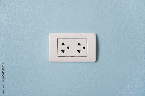 Electrical plug socket on the blue cement wall. Energy use in home. Electricity consumption.