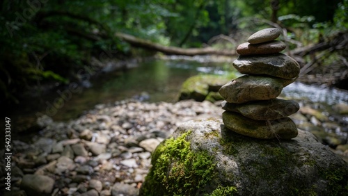 Closeup of stacked rocks in background of flowing river