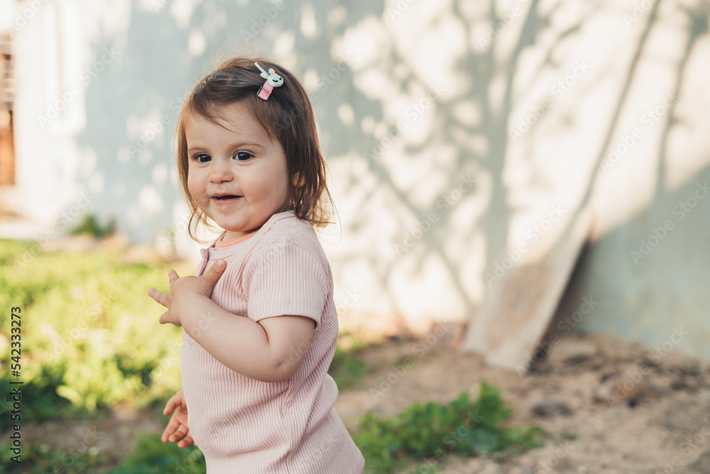 Cute adorable little caucasian kid girl having fun playing in the backyard at home. Happy childhood, children's healthcare. Positive emotions. Smiling happy Cute adorable little caucasian kid girl having fun playing in the backyard at home. Happy childhood, children's healthcare. Positive emotions. Smiling happy