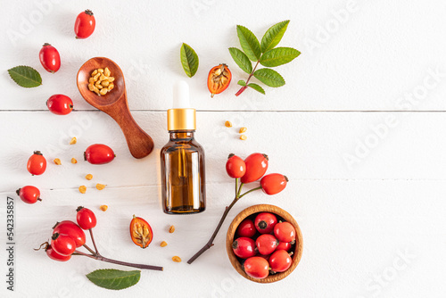Foto cosmetic bottle with a pipette with organic rosehip seed oil on a white wooden background