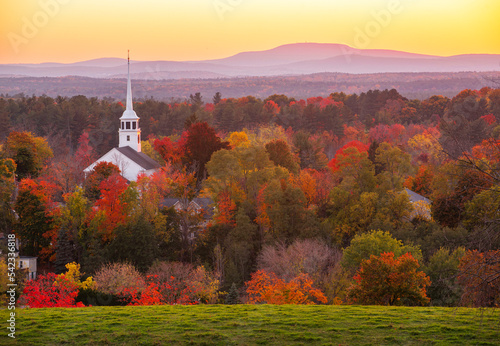 Fototapeta Naklejka Na Ścianę i Meble -  landscape of church tower in autumn mountain forest during sunset