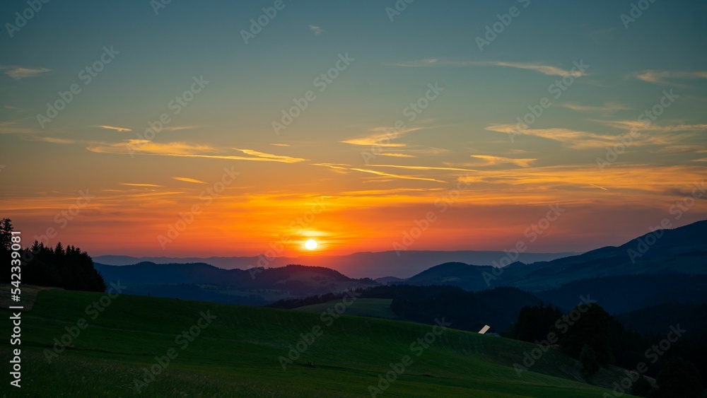 Beautiful shot of green field in mountains in the Black Forest, Germany at sunset