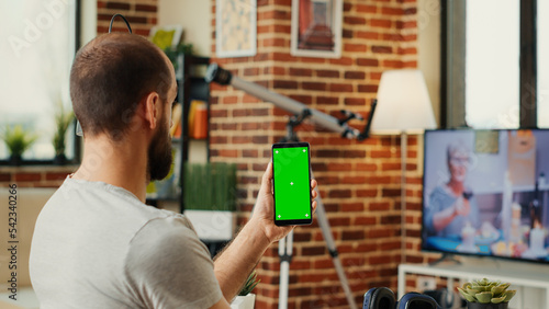 Office worker analyzing smartphone with greenscreen template, using isolated display with chroma key and copyspace. Working with blank mockup background on wireless mobile phone.