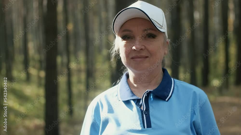 Portrait of an elderly senior woman after a morning jog in a sunny forest. A pensioner who cares about his health goes in for sports. Healthy lifestyle. Portrait of an elderly senior woman after a morning jog in a sunny forest. A pensioner who cares about his health goes in for sports. Healthy lifestyle.