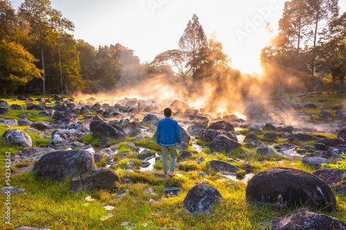 Canvastavla Male tourist standing and looking at Natural hot spring with steam, and rock in the morning at Chae Son National Park, Lampang, Thailand