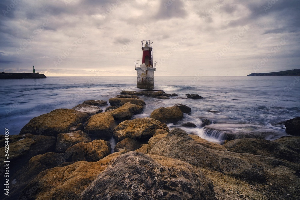 Panoramic shot of an old lighthouse in the middle of a stormy sea