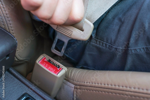 Male hand fastens the seat belt in the car close-up.