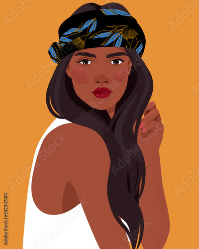 Black African  girl is wearing a animal tiger print turban. Self-confident young woman with brown skin in traditional headdress portrait front view. 
