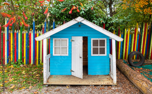 A small playhouse for children and a fence in the shape of colored pencils