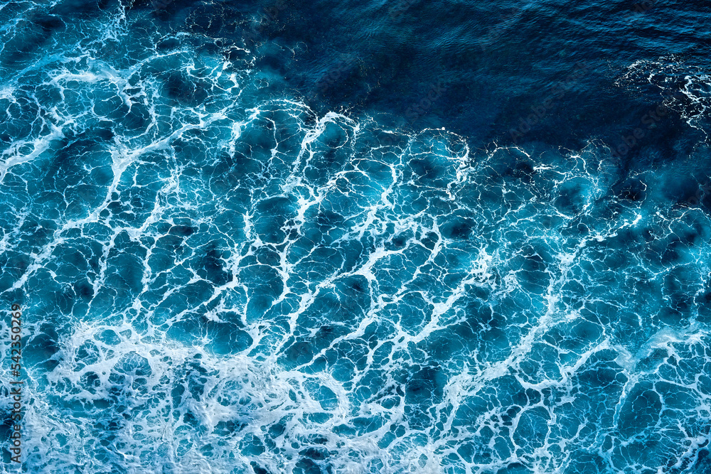Obraz premium Aerial view to seething waves with foam. Waves of the sea meet each other during high tide and low tide