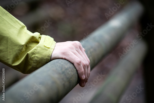 Close-up of hand on wooden railing outdoors , blured background © STOATPHOTO