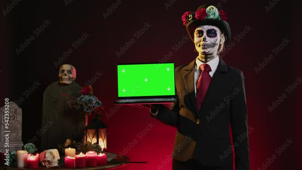 Scary female model holding laptop with greenscreen display, showing ...