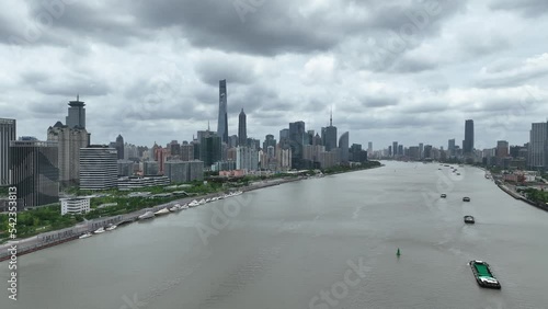 City Skyline and boats in the Hunagpu River. Drone aerial view. Dramatic cities skylines in a cloudy day and river with boats.  City scape, business, economy concept b-roll footage. photo