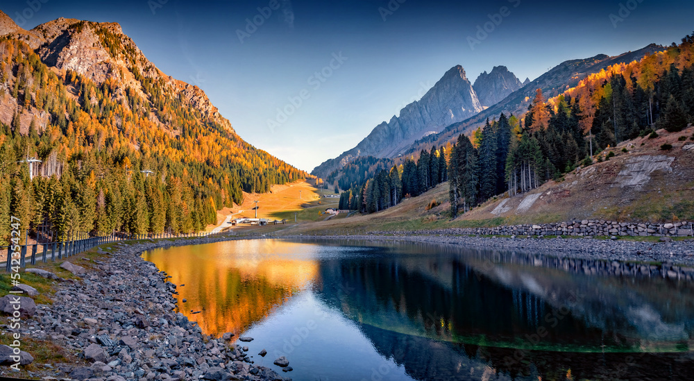 Calm autumn scene of Italy, Europe. Dolomite Alps reflected in the calm waters of Malga Ces Lake.  Beauty of nature concept background.