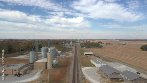 Aerial drone shot flying over a railroad close to silos in the american countryside. photo