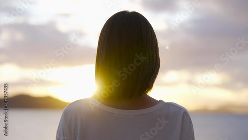 夕暮れの海にいる女性