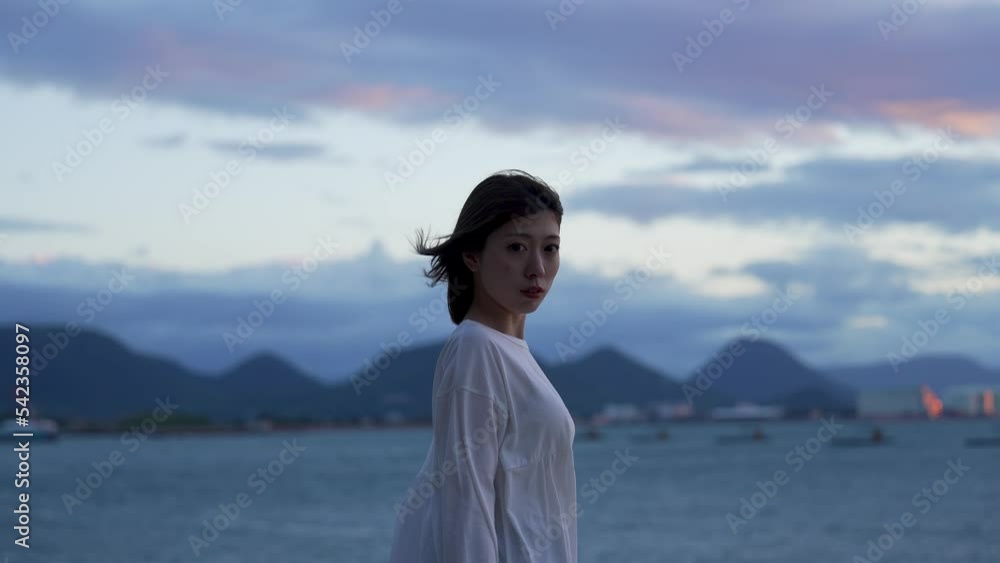 夕暮れの海にいる女性