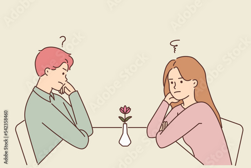 Unhappy man and woman at table in cafe