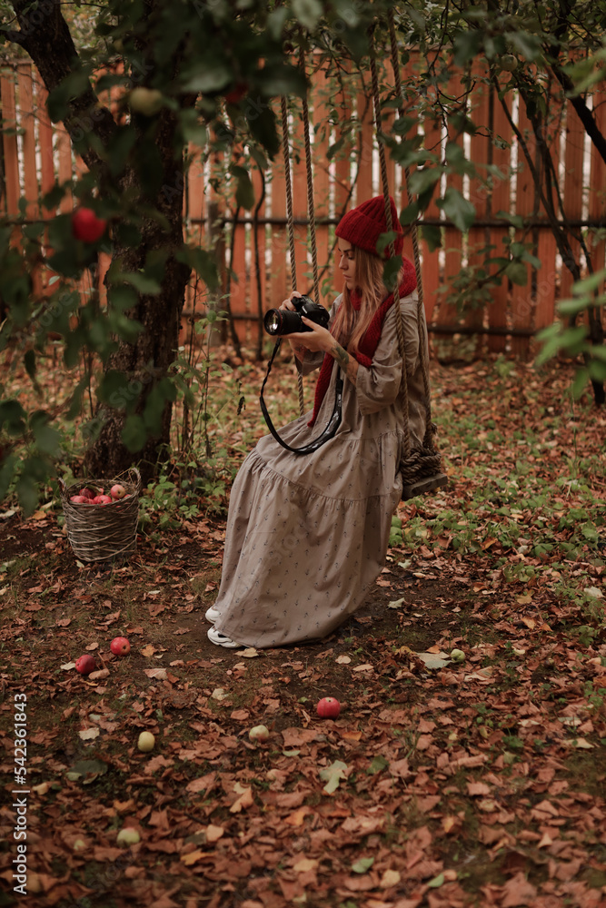 girl photographer on a swing in the autumn garden girl photographer on a swing in the autumn garden