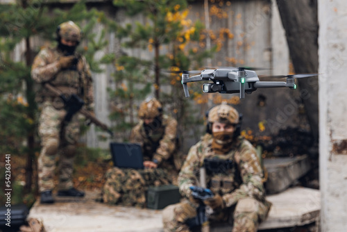 Bild auf Leinwand Military soldier controls drone for reconnaissance operation of enemy positions