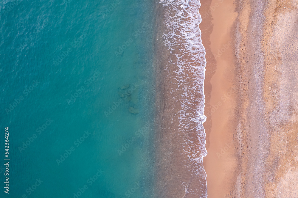 Fototapeta premium Turquoise water with wave with sand beach background from aerial top view. Concept summer sunny travel image