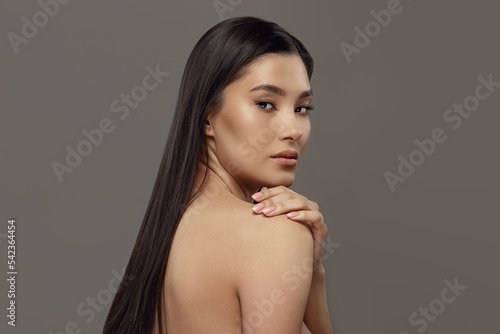 Luxurious young woman with naked back, long dark hair.