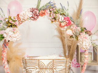 pink and white decoration for a 1st birthday cake smash studio photo shoot with balloons, paper decor, cake and topper. High quality photo