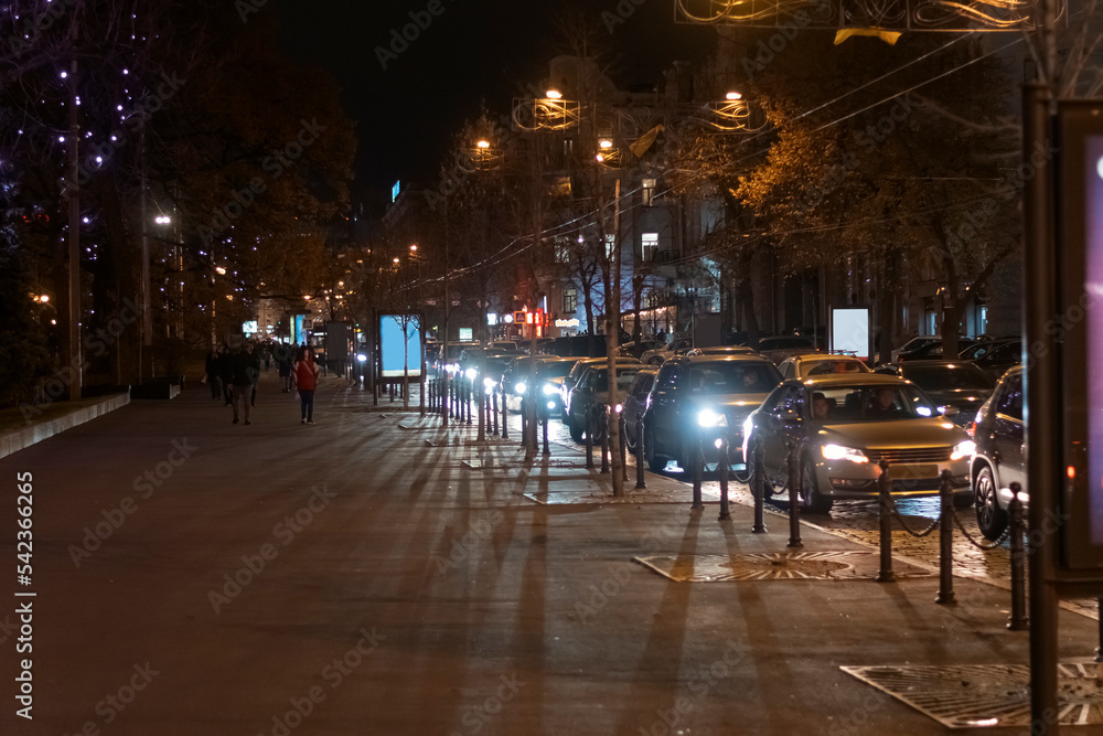 Illumination of evening city. Traffic jam on road in city center in evening or at night. Illuminated road with cars