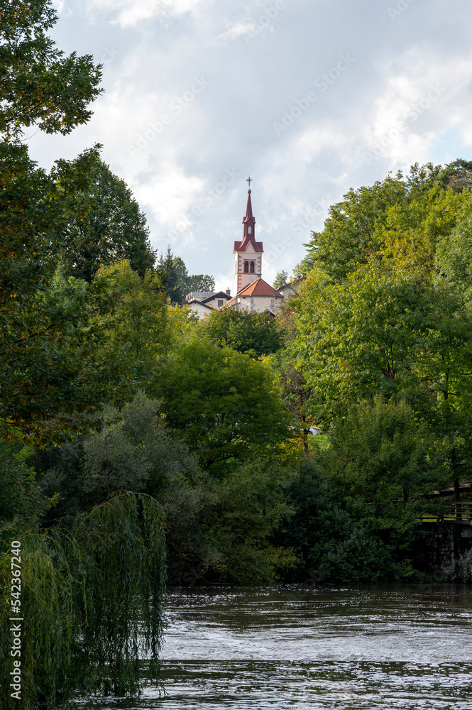 La rivière Pivka et le clocher de l'église Sainte Catherine autour des grottes de Postojna en Slovénie à l'automne