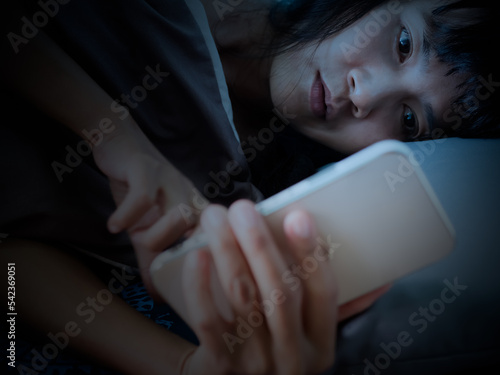 Woman Sleep on Bed and Looking Mobile in Night,She Wait Call Back from Husband with Sad and stressed,Lonely,Girl Unhappy Broken Heart and Problem,Authentic Black Hair and Skin Tan Asian.