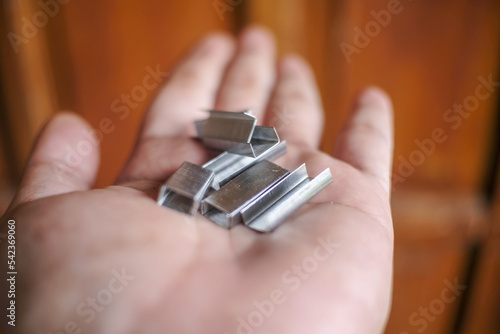 Sharp metal stapler refill on a wooden background