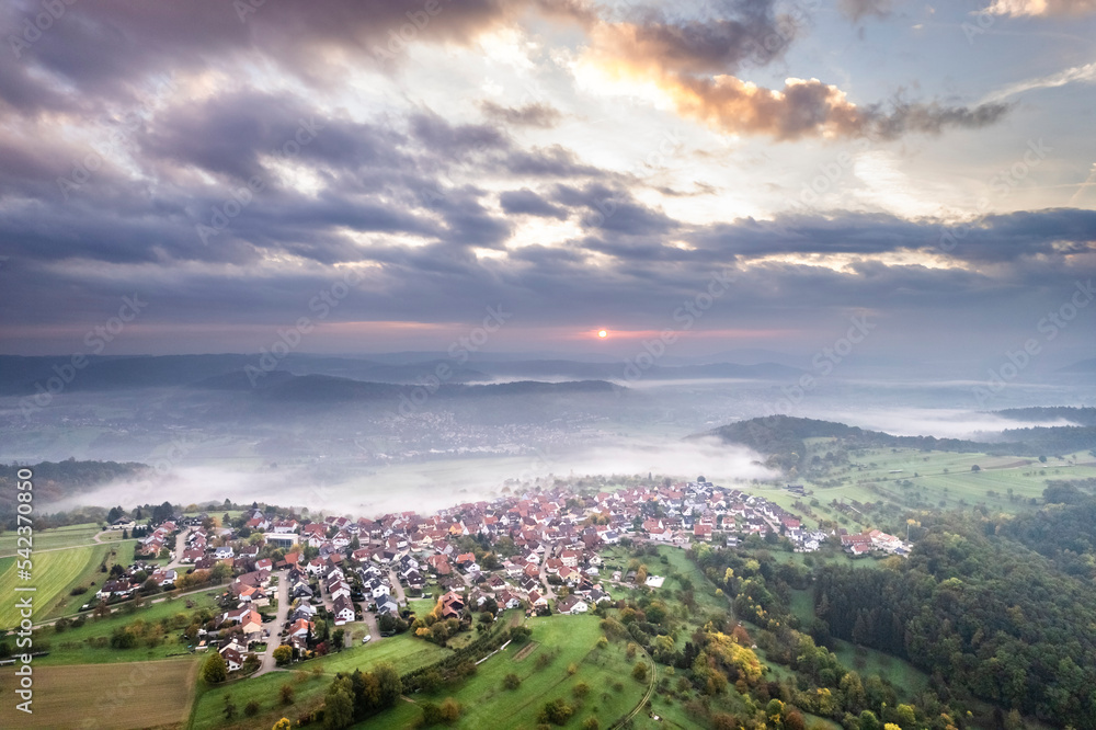 Germany, Baden-Wurttemberg, Drone view of clouds over village in Remstal valley at foggy autumn sunrise Germany, Baden-Wurttemberg, Drone view of clouds over village in Remstal valley at foggy autumn sunrise