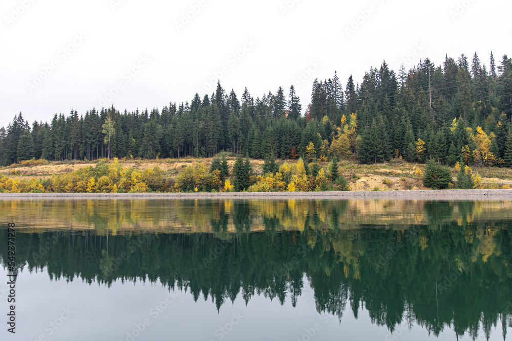 Natural background, lake and forest in the mountains in autumn.