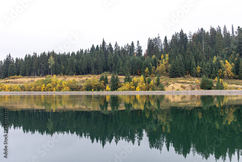 Natural background, lake and forest in the mountains in autumn.
