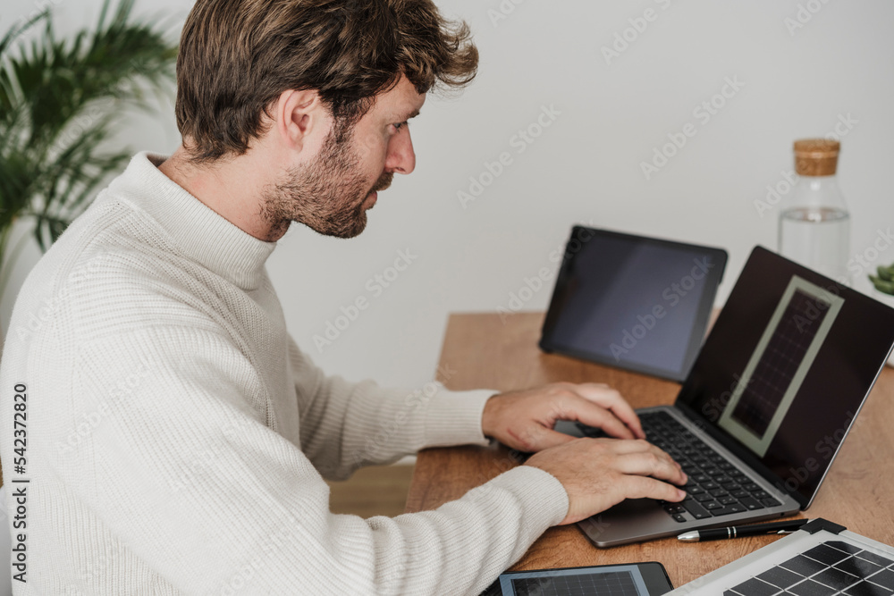 Businessman typing on laptop at desk in workplace Businessman typing on laptop at desk in workplace