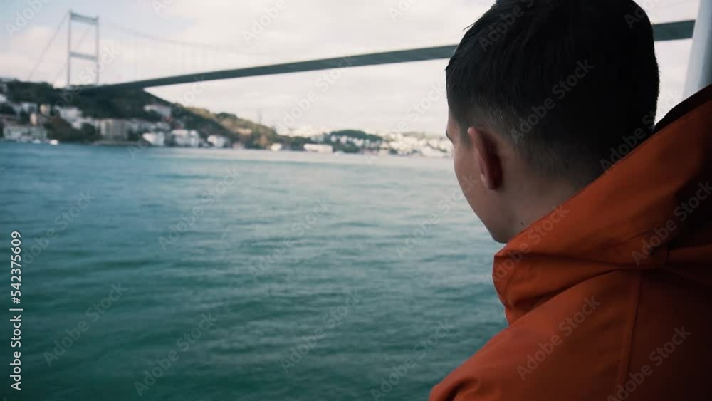 man with red coat traveling on the ferry near Bosphorus in Turkey. man with red coat traveling on the ferry near Bosphorus in Turkey.
