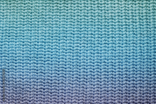 Top view of a knitted fabric made of wool of purple blue aquamarine green gradient color