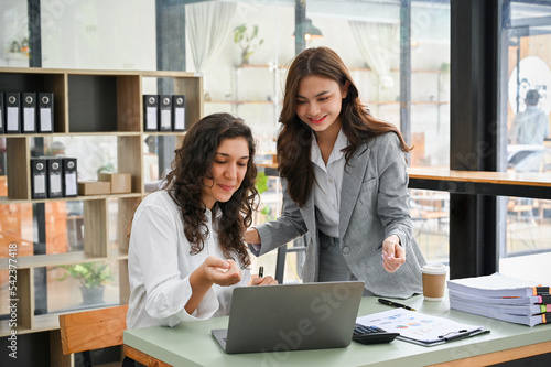 Cheerful caucasian businesswoman working with her coworker in the office.