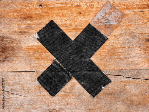 the "X" sign on the wood made of black tape as a no-occupation sign 