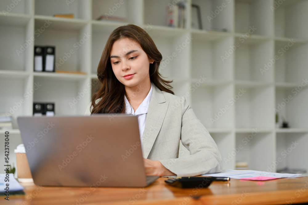 Professional caucasian businesswoman concentrating on her business project on laptop Professional caucasian businesswoman concentrating on her business project on laptop