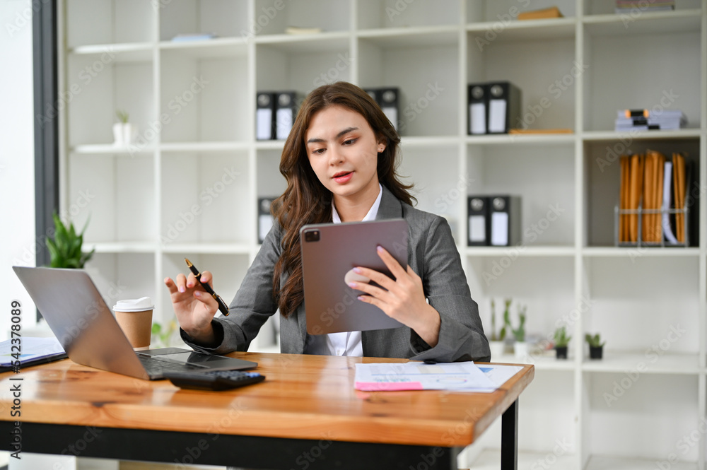 Attractive Caucasian businesswoman concentrating on her tasks in her office Attractive Caucasian businesswoman concentrating on her tasks in her office