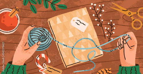 Wrapping Christmas gift in festive paper, decorating present box with DIY decoration, twine. Hands at table, preparing Xmas package decor for winter holiday, top view. Flat vector illustration