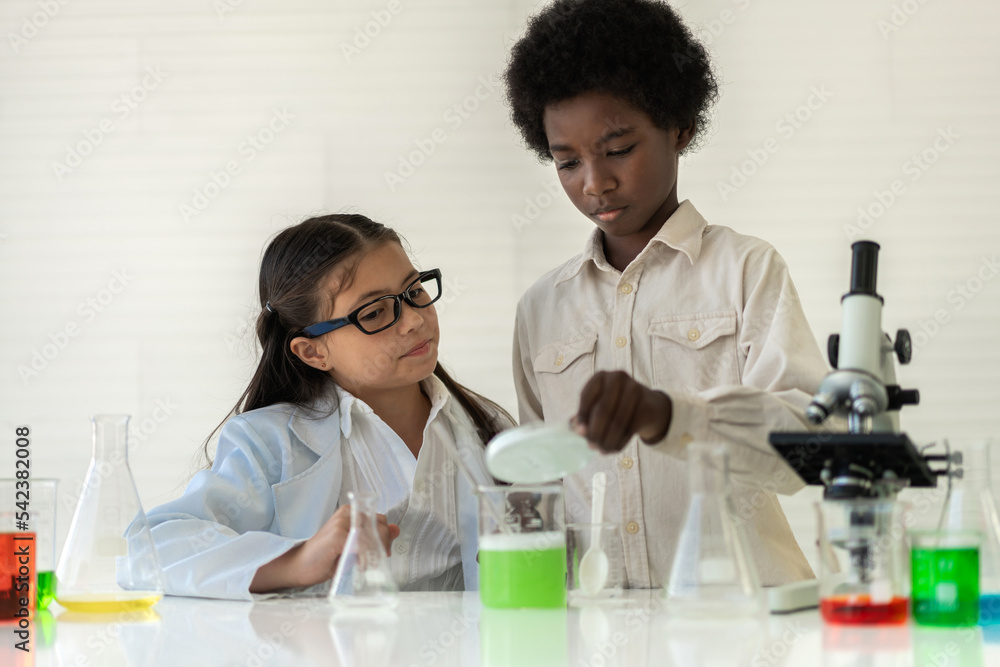 Group of teenage student learn with teacher and study doing a chemical experiment and holding test tube in hand in the experiment laboratory class on table at school.Education concept Group of teenage student learn with teacher and study doing a chemical experiment and holding test tube in hand in the experiment laboratory class on table at school.Education concept