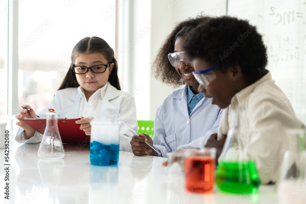 Group of teenage student learn with teacher and study doing a chemical experiment and holding test tube in hand in the experiment laboratory class on table at school.Education concept Group of teenage student learn with teacher and study doing a chemical experiment and holding test tube in hand in the experiment laboratory class on table at school.Education concept