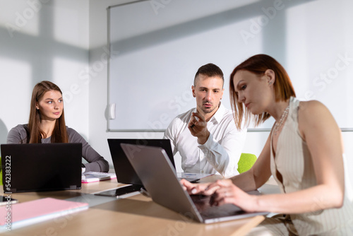 Colleagues in the meeting room communicate about a business project © makedonski2015